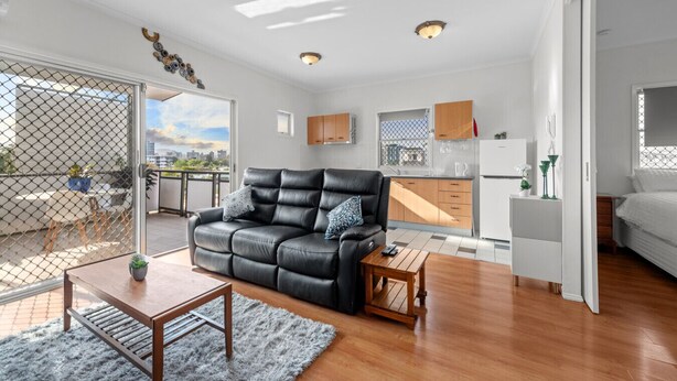 Un appartement moderne comprenant un salon, une cuisine et un balcon.