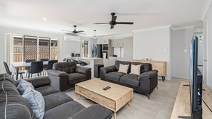 En moderne stue med en sofa, et sofabord og et fjernsyn.