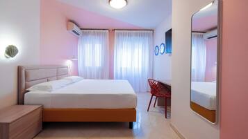 A bedroom with a bed, bedside table, chair, and a large mirror.