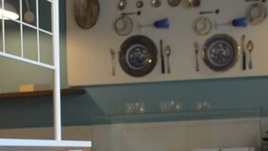 Una cocina con encimera de mármol, protector contra salpicaduras de vidrio y un colgador de utensilios en la pared.
