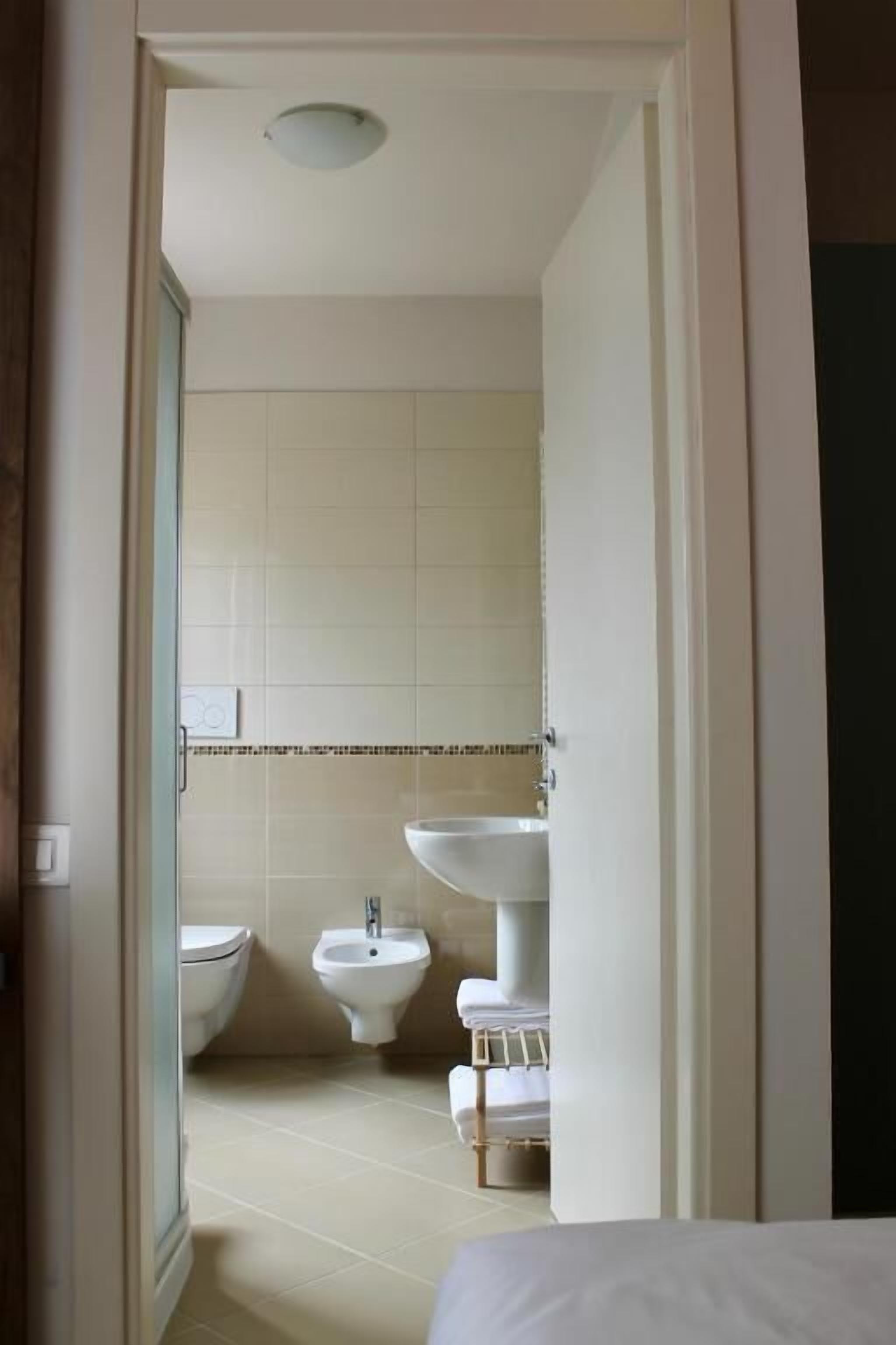 A bathroom with a toilet, bidet, and sink.