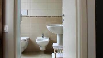 A bathroom with a toilet, bidet, and sink.