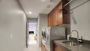 Una cocina moderna con electrodomésticos de acero inoxidable, armarios de madera y un lavamanos empotrado.