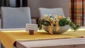 A table with a bowl of decorative flowers and a small sign.