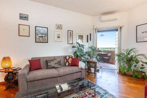 Ein Wohnzimmer mit einer Couch, einem Couchtisch und verschiedenen gerahmten Bildern an der Wand.