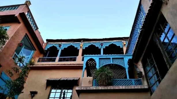 A building with a traditional architectural style, featuring arched windows and decorative lattice work. - MAISON DES MAÎTRES  (Ourika)