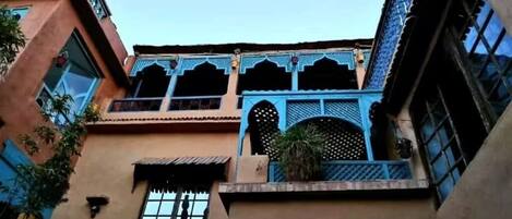 A building with a traditional architectural style, featuring arched windows and decorative lattice work.