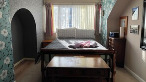 A bedroom with a bed, a wooden bench, a dresser, and a window with curtains. - Sheffield's 3BR Retreat (Sheffield)