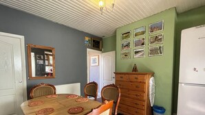 A dining area with a wooden table and chairs, a dresser, and a refrigerator. - Sheffield's 3BR Retreat (Sheffield)