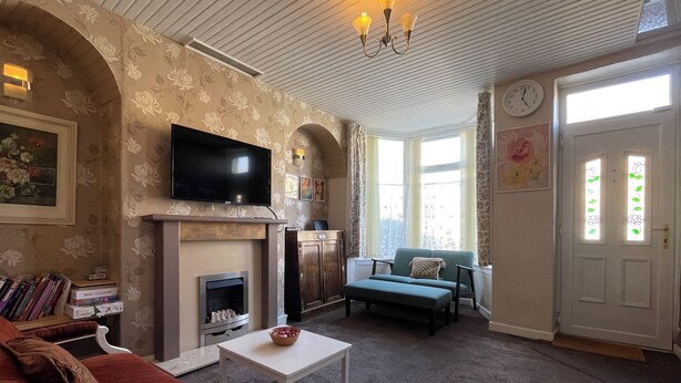 A living room with a fireplace, television, sofa, and a small table. - Sheffield's 3BR Retreat (Sheffield)