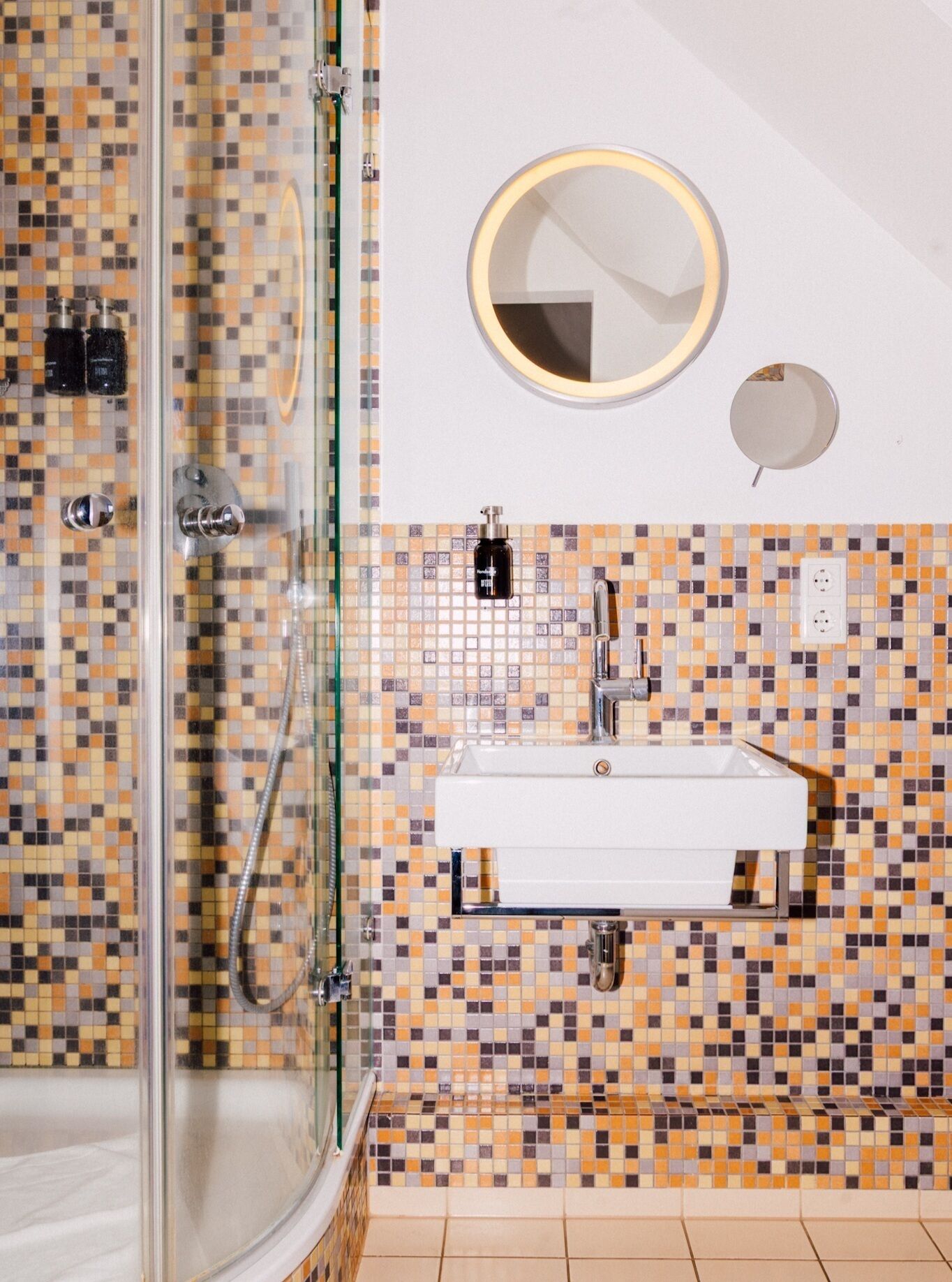 Ein Badezimmer mit Dusche, Waschbecken und Spiegel.