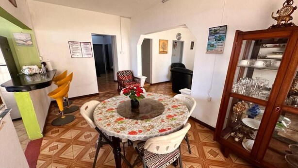 A dining area with a round table, chairs, and a cabinet with glassware. - Chic 2-bedroom apartment with WiFi, fitness room in vibrant Vacoas-Phoenix (Vacoas-Phoenix)