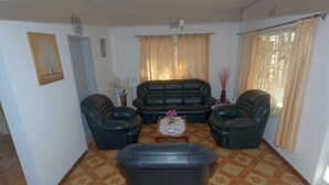 A living room with a sofa set, two armchairs, a coffee table, and a decorative vase. - Chic 2-bedroom apartment with WiFi, fitness room in vibrant Vacoas-Phoenix (Vacoas-Phoenix)