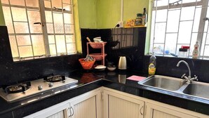 A kitchen with white cabinets, a black countertop, a gas stove, a sink, and a window with a view. - Chic 2-bedroom apartment with WiFi, fitness room in vibrant Vacoas-Phoenix (Vacoas-Phoenix)