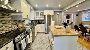 A modern kitchen with granite countertops, stainless steel appliances, and a central island. - Luxury Modern Retreat: w/ Sauna & Modern Amenities (Mississauga)