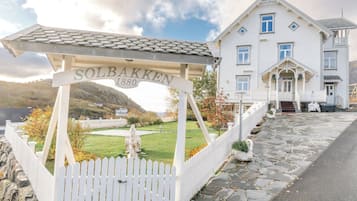 A white building with a stone roof and a sign reading 'Solbakken 1880'.