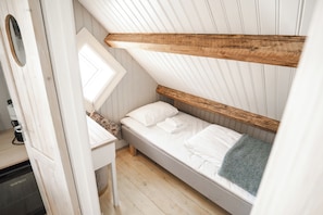 A compact bedroom with a bunk bed, a small desk, and a window. - Sakrisøy Gjestegård-Solbakken anno 1880 (Nordland)