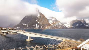 A bridge over a body of water with a mountainous backdrop.