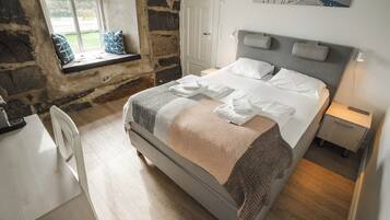 A bedroom with a bed, a window, a desk, and a chair.