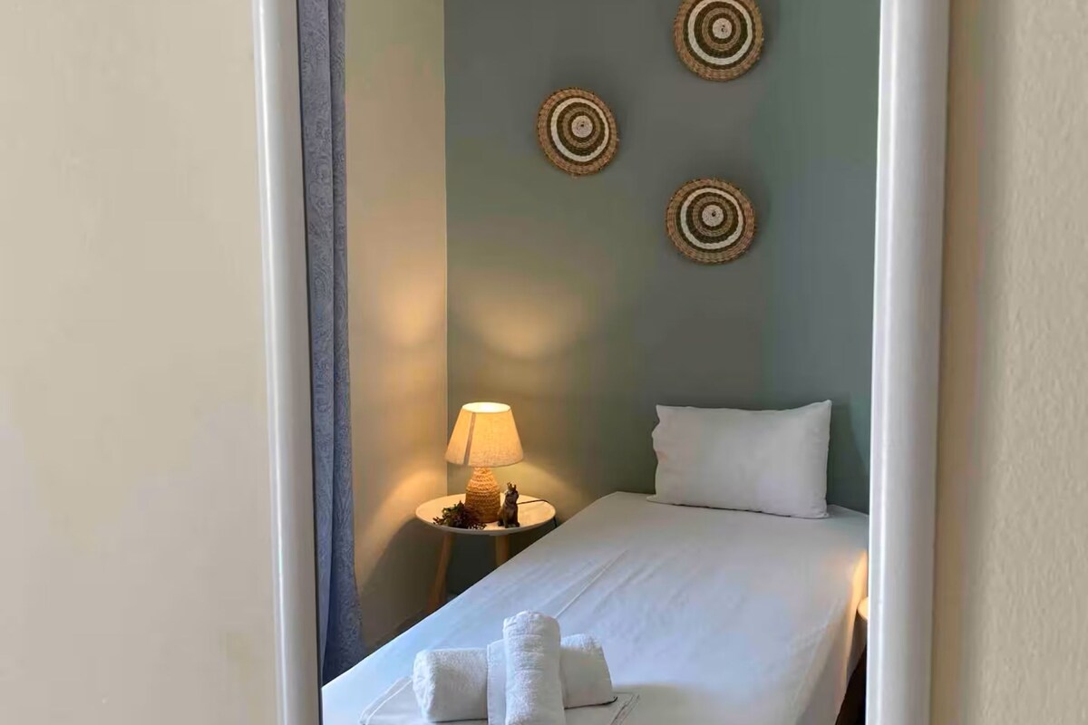 Une chambre d’hôtel avec un lit, une table de chevet avec une lampe et des œuvres d’art décoratives au mur.