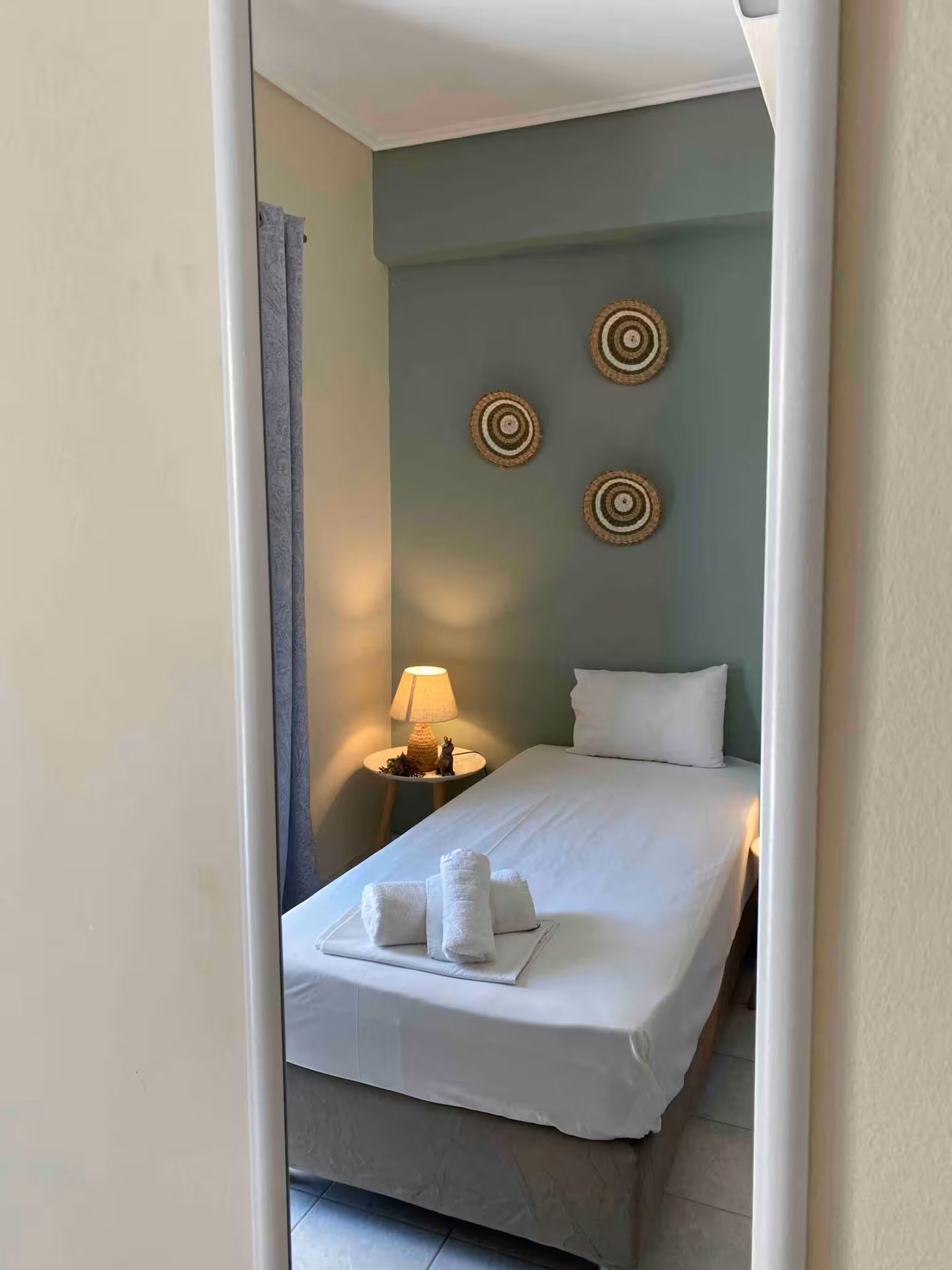 Ein Hotelzimmer mit einem Bett, einem Nachttisch mit Lampe und dekorativer Wandkunst.