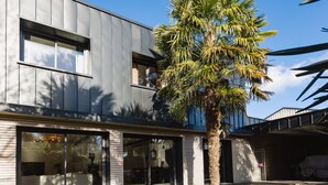 Un bâtiment moderne doté de grandes fenêtres et d’un espace extérieur abrité.