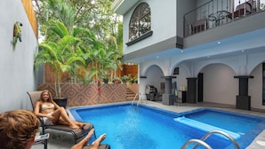 An indoor swimming pool with a view of the outdoors, including a balcony and plants. - Brasilito 1 (Brasilito)