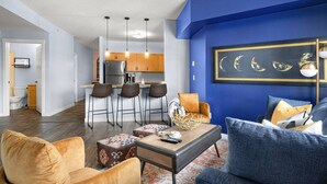 Una sala moderna con una pared azul de acento, una mesa de centro y asientos.