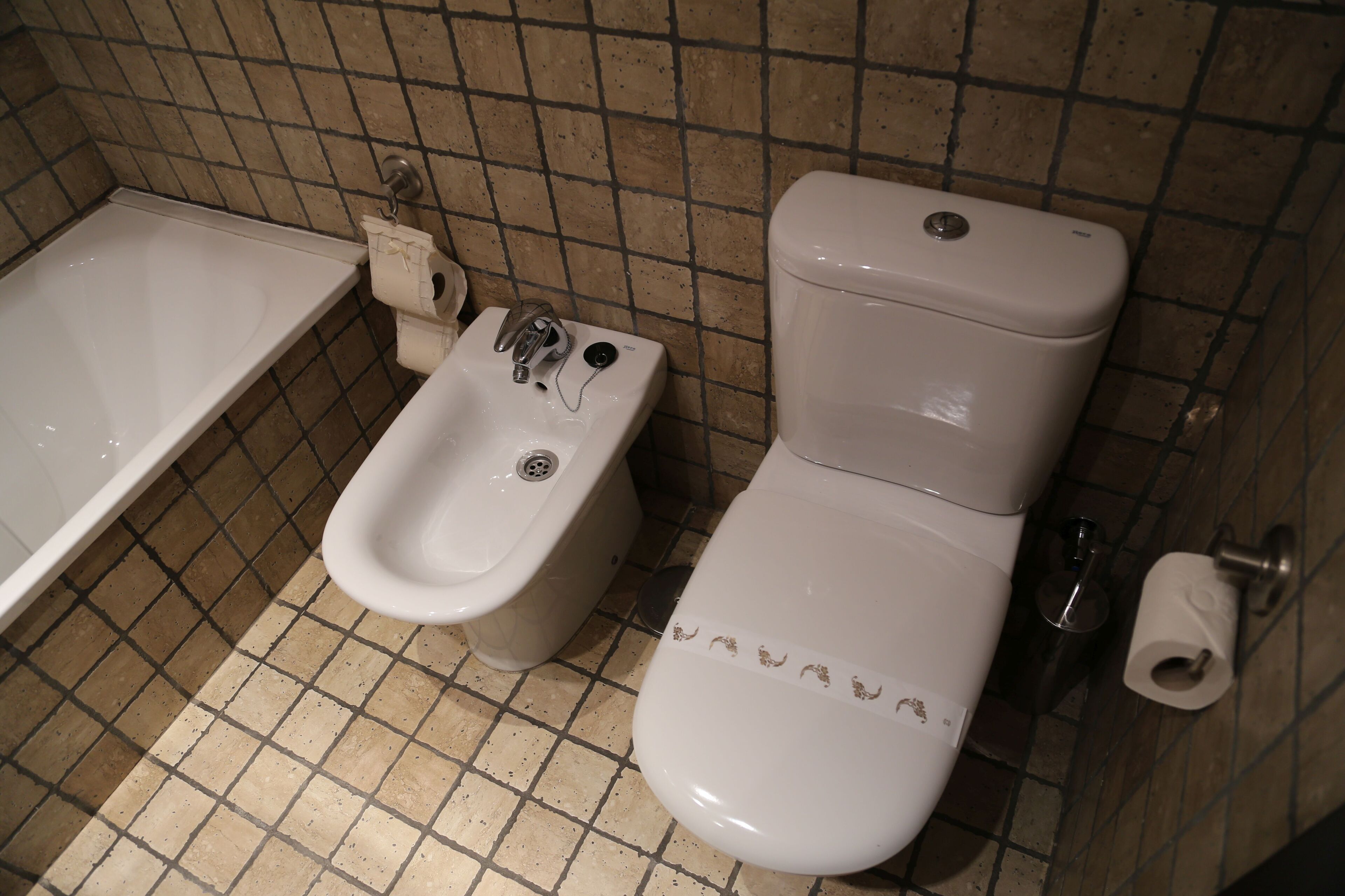 A bathroom with a bathtub, a bidet, and a toilet.