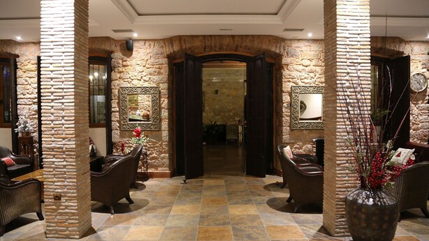 A lobby with stone walls, a tiled floor, and a reception desk. - La Pontiga (Pilona)