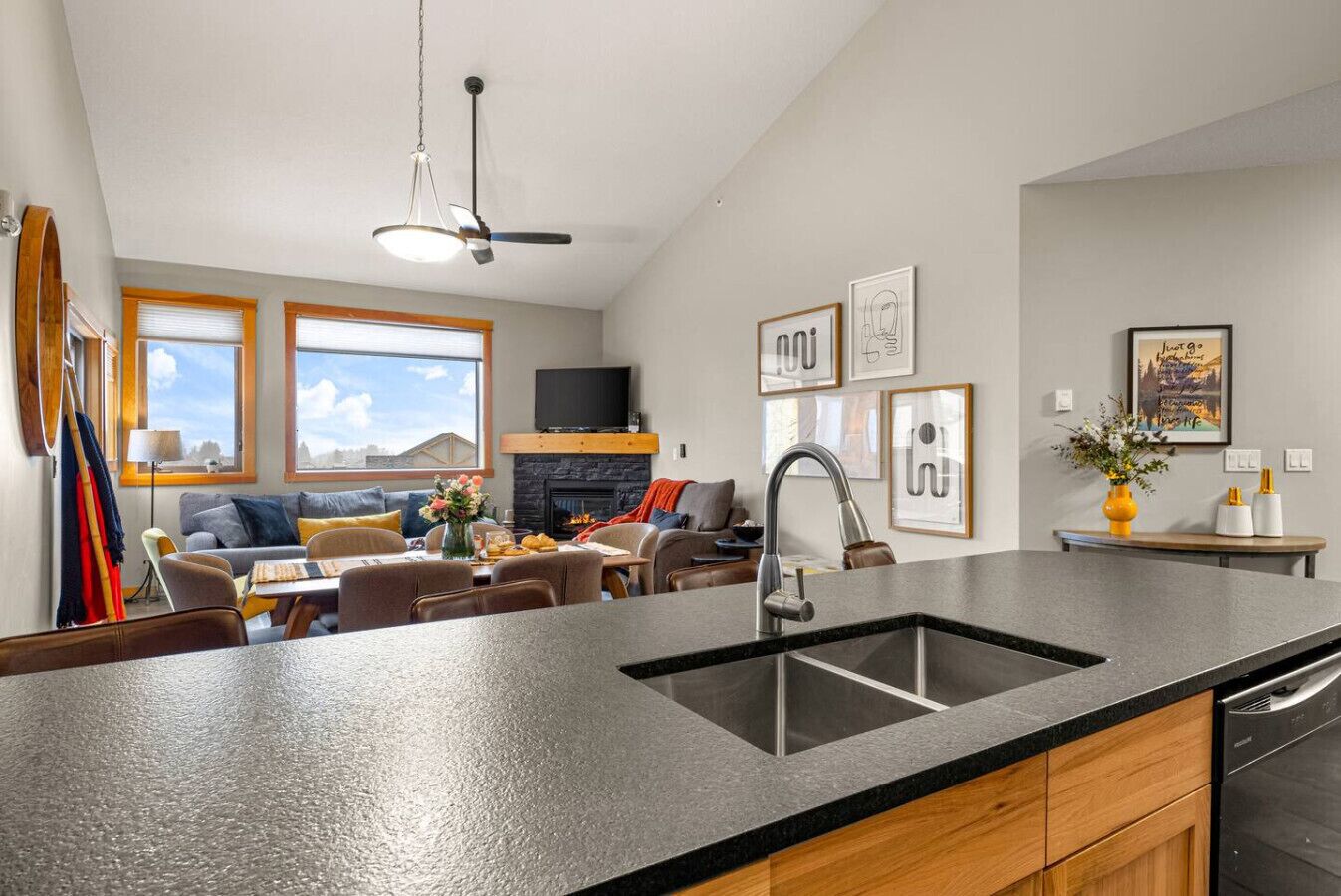 A modern kitchen with a large island, a fireplace, and a dining area with a sofa and chairs.