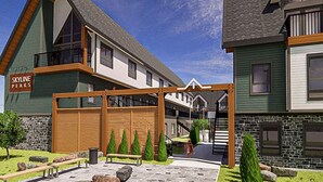 Un edificio residencial con terraza de madera, sendero de piedra y un letrero que dice "SKYLINE PEAKS".