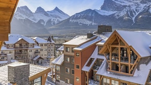 Un complejo turístico de montaña con edificios de varios pisos, balcones de madera y techos cubiertos de nieve.