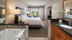 A hotel room with a large bed, a sitting area with a view, a bathroom with a bathtub, and a sink.