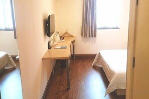 A hotel room with a bed, a desk with a chair, a television, and a window with curtains. - Homeinn Pebble Hotel (Beijing West Railway Station South Square) (Beijing)