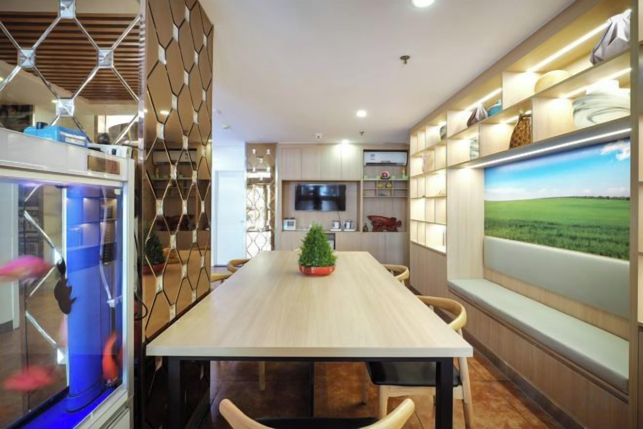 Un comedor moderno con una mesa larga, sillas, un acuario y un ventanal con vistas al paisaje.