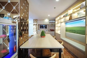 A modern dining area with a long table, chairs, a fish tank, and a large window with a landscape view. - Homeinn Pebble Hotel (Beijing West Railway Station South Square) (Beijing)