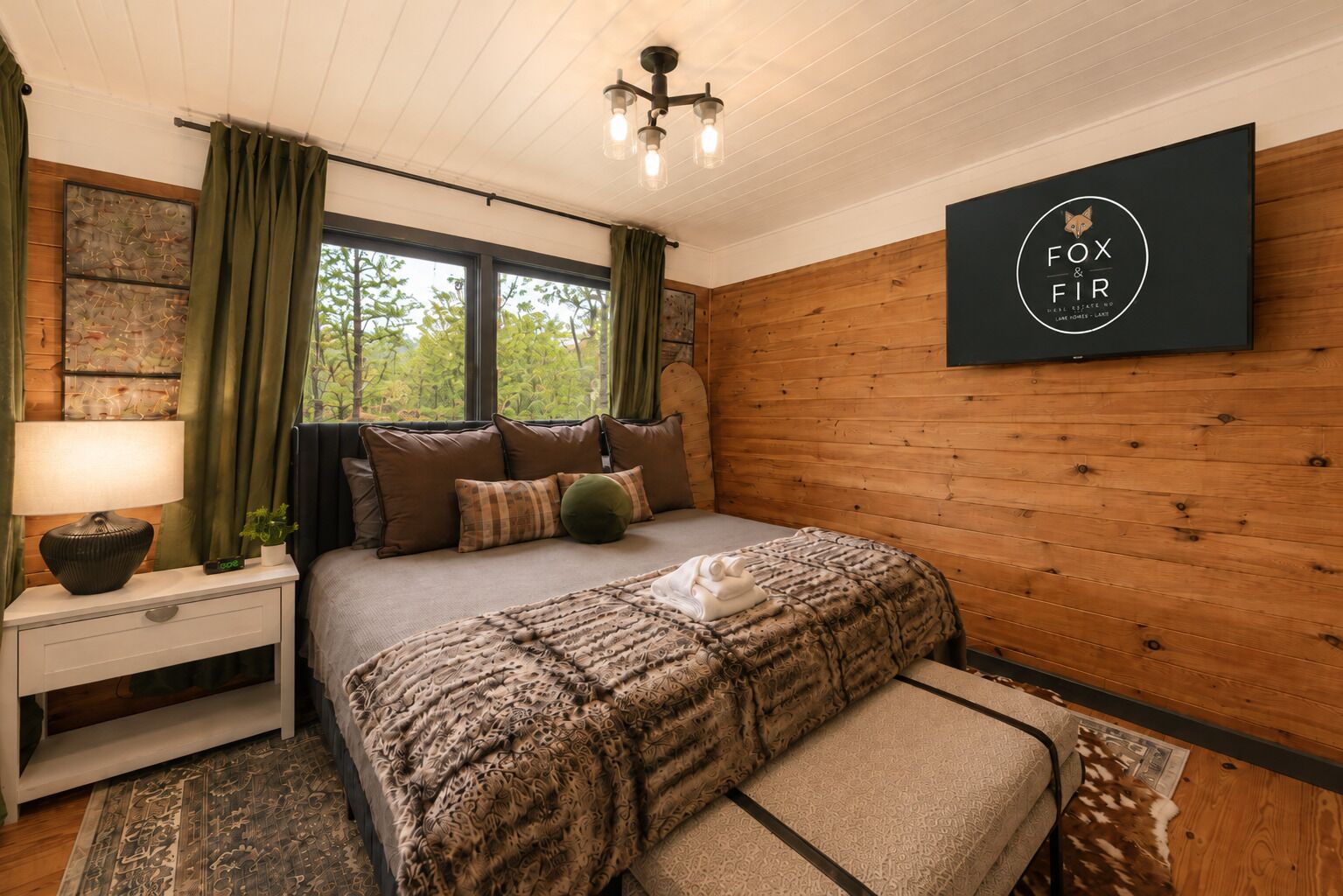 Un dormitorio con cama, mesita de noche, lámpara y un cartel en la pared.