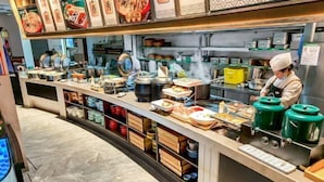 Una mesa de buffet con diversos alimentos y equipos de cocina.