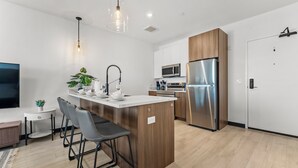 Uma cozinha moderna com ilha central, eletrodomésticos de aço inoxidável e design minimalista.