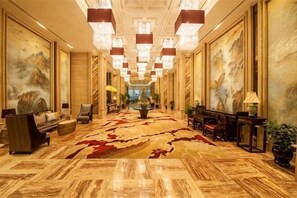 A spacious lobby with a large carpet, seating area, and artwork on the walls. - Hebei Hotel Executive Apartment (VIP Building) (Shijiazhuang)