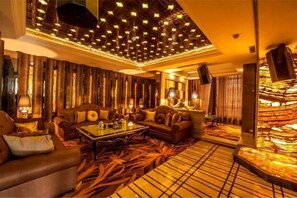 Un amplio salón con techo alto, asientos cómodos y suelo estampado.