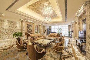 A spacious living room with a high ceiling, marble walls, and a large chandelier. - Hebei Hotel Executive Apartment (VIP Building) (Shijiazhuang)