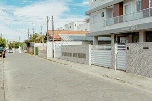 A residential building with a gated entrance, a covered parking area, and a visible sign indicating it is a residential property. - Residencial Diva (Florianópolis)