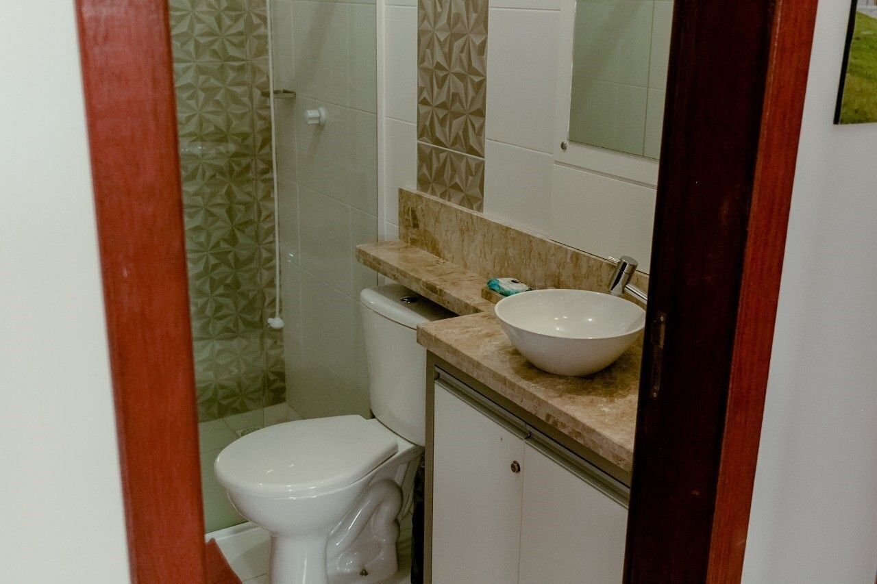 Une salle de bain comprenant des toilettes, un lavabo et une douche.