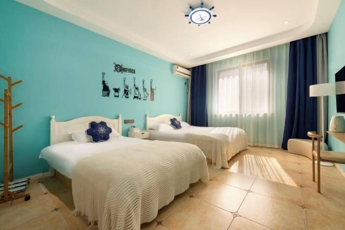Ein Hotelzimmer mit zwei Betten, einer Uhr, einer Wanddekoration und einem Fenster mit Vorhängen.
