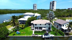 A waterfront property with multiple buildings, a dock with boats, and a marina.
