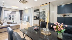 Un salon moderne avec une table à manger noire, un canapé et un grand miroir.