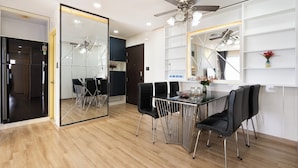 Un espace repas moderne doté d’une cloison en verre, d’un ventilateur de plafond et d’un intérieur blanc.