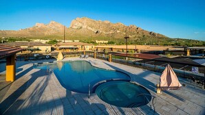 Una piscina con vistas a montañas al fondo.